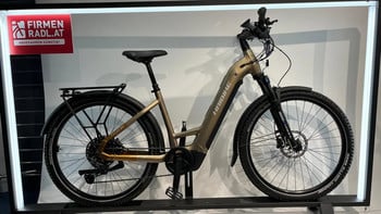 Ein goldenes Haibike E-Bike mit Gepäckträger und Schutzblechen steht ausgestellt.