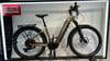 Ein goldenes Haibike E-Bike mit Gepäckträger und Schutzblechen steht ausgestellt.