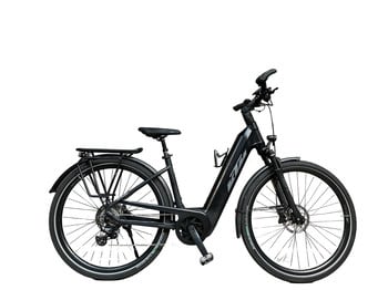 Ein schwarzes KTM E-Bike mit Gepäckträger und Schutzblechen steht auf weißem Grund.