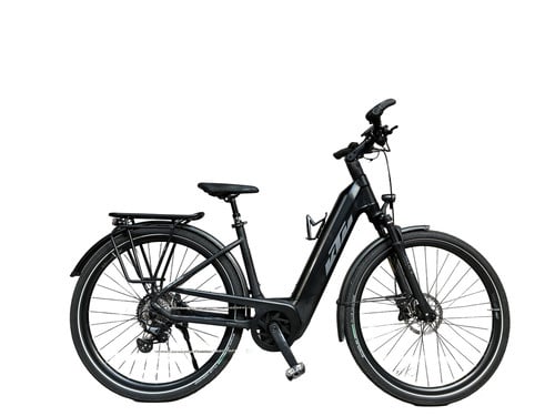 Ein schwarzes KTM E-Bike mit Gepäckträger und Schutzblechen steht auf weißem Grund.