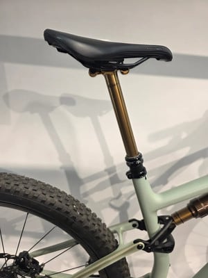 Goldene Sattelstütze mit schwarzem Sattel auf einem hellgrünen Fahrrad. Goldene Sattelstütze mit schwarzem Sattel auf einem hellgrünen Fahrrad.
