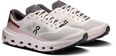Beige Laufschuhe mit rosa und dunklen Akzenten und weißen Schnürsenkeln. Beige Laufschuhe mit rosa und dunklen Akzenten und weißen Schnürsenkeln.
