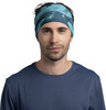 Ein Mann mit einem blauen Stirnband und einem blauen T-Shirt vor weißem Hintergrund.