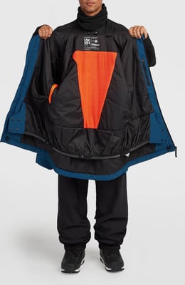 Ein Mann betrachtet das Innere einer blauen Jacke mit orangefarbenem Futter.