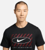 Ein Mann in einem schwarzen T-Shirt mit dem Nike-Logo und dem Schriftzug Nike Sportswear.