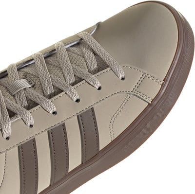 Nahaufnahme eines Adidas-Sneakers mit Schnürsenkeln und Seitenstreifen. Nahaufnahme eines Adidas-Sneakers mit Schnürsenkeln und Seitenstreifen.