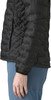 Schwarze gesteppte Jacke mit blauer Hose und Hand im Vordergrund.