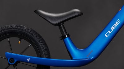 Blaues Kinderfahrrad mit schwarzem Sattel und weißem CUBE-Logo. Blaues Kinderfahrrad mit schwarzem Sattel und weißem CUBE-Logo.