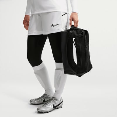 Ein Fußballspieler hält eine schwarze Tasche mit weißem Nike-Logo.