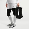 Ein Fußballspieler hält eine schwarze Tasche mit weißem Nike-Logo.