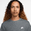 Ein Mann mit lockigem Haar trägt ein dunkles T-Shirt mit Nike-Logo.