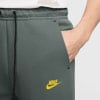 Graue Nike Jogginghose mit gelbem Logo und Kordelzug.