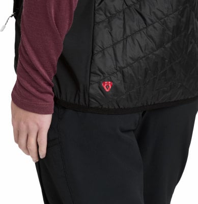 Detail einer schwarzen Damenweste mit rotem Logo und schwarzer Hose. Detail einer schwarzen Damenweste mit rotem Logo und schwarzer Hose.