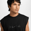 Ein Mann in einem schwarzen Tanktop mit Nike-Logo und Hanteln.