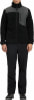 Mann in schwarzer Fleecejacke mit grauen Einsätzen und schwarzer Hose.