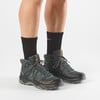 Blick auf Füße in schwarzen Socken und Salomon Outdoor-Stiefeln.