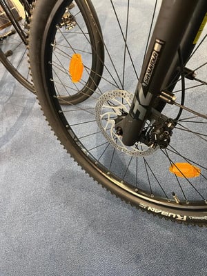 Vorderrad eines Mountainbikes mit Scheibenbremse und orangefarbenem Reflektor. Vorderrad eines Mountainbikes mit Scheibenbremse und orangefarbenem Reflektor.