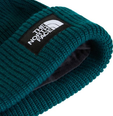 Grüne Strickmütze mit The North Face Logo auf schwarzem Patch. Grüne Strickmütze mit The North Face Logo auf schwarzem Patch.