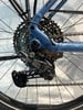 Nahaufnahme einer Shimano CUES Fahrrad-Schaltwerk an einem blauen Rahmen.