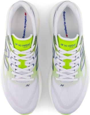 Draufsicht auf weiße New Balance Laufschuhe mit neongrünen Akzenten. Draufsicht auf weiße New Balance Laufschuhe mit neongrünen Akzenten.