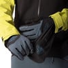 Eine Person zieht Handschuhe für Wintersport über einen Jackenärmel.