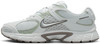 Fehér Nike cipő finom zöld akcentussal és szürke logóval.