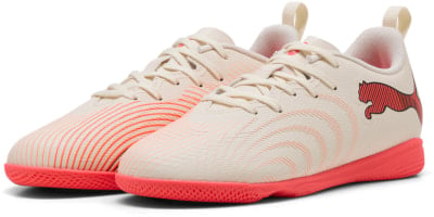 Beige Hallenschuhe von Puma mit orangefarbenem Streifendesign und Logo. Beige Hallenschuhe von Puma mit orangefarbenem Streifendesign und Logo.