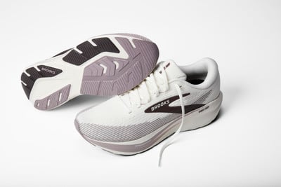 Weiße Brooks Laufschuhe mit lila und dunkelbraunen Akzenten auf weißem Hintergrund. Weiße Brooks Laufschuhe mit lila und dunkelbraunen Akzenten auf weißem Hintergrund.