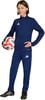 Ein Junge im dunkelblauen Trainingsanzug hält einen Fußball und trägt Fußballschuhe.