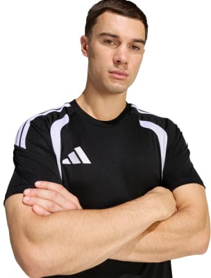Ein Mann in einem schwarzen T-Shirt mit weißen Streifen an den Schultern, Arme verschränkt. Ein Mann in einem schwarzen T-Shirt mit weißen Streifen an den Schultern, Arme verschränkt.