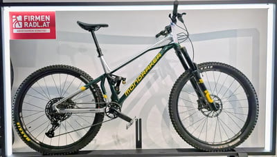 Ein grünes Mondraker Mountainbike mit Rahmenaufschrift und Firmenlogo. Ein grünes Mondraker Mountainbike mit Rahmenaufschrift und Firmenlogo.