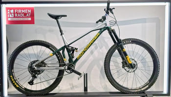 Ein grünes Mondraker Mountainbike mit Rahmenaufschrift und Firmenlogo.