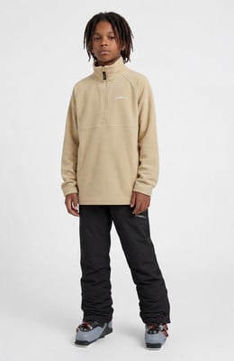 Junge in beige O'Neill Fleece-Pullover und schwarzer Skihose.