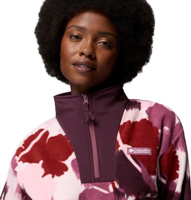 Eine Frau mit Afro-Frisur trägt einen Fleece-Pullover mit Blumenmuster. Eine Frau mit Afro-Frisur trägt einen Fleece-Pullover mit Blumenmuster.