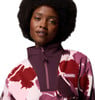 Eine Frau mit Afro-Frisur trägt einen Fleece-Pullover mit Blumenmuster.