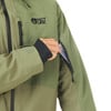 Ein Mann steckt eine Karte in die Ärmeltasche einer grünen Jacke.