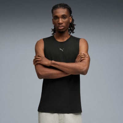 Ein Mann in einem schwarzen Tanktop mit Puma-Logo und verschränkten Armen. Ein Mann in einem schwarzen Tanktop mit Puma-Logo und verschränkten Armen.