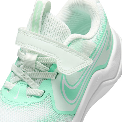 Nahaufnahme eines weiß-mintfarbenen Nike-Kinderschuhs mit Klettverschluss.