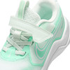 Nahaufnahme eines weiß-mintfarbenen Nike-Kinderschuhs mit Klettverschluss.