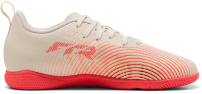 Beige Fußballschuhe mit orange-gestreiftem Design und roter Sohle. Beige Fußballschuhe mit orange-gestreiftem Design und roter Sohle.