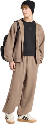 Ein Mann im braunen Jogginganzug und schwarzem T-Shirt mit Rucksack. Ein Mann im braunen Jogginganzug und schwarzem T-Shirt mit Rucksack.