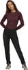 Frau in bordeauxrotem Langarmshirt und schwarzer Hose.