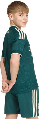 Junge in grünem Fußballtrikot und Shorts mit weißen Streifen. Junge in grünem Fußballtrikot und Shorts mit weißen Streifen.