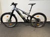 Graues Mountainbike mit schwarzen Rädern und grünen Details.