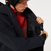 Ein Mann verstaut sein Handy in der Innentasche einer schwarzen Jacke.