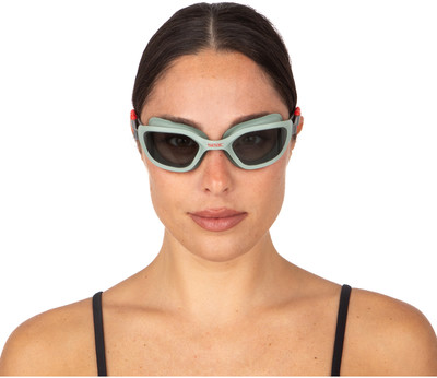 Frau mit Schwimmbrille auf weißem Hintergrund.