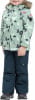 Mädchen in einer Winterjacke mit Baum- und Bärchenmuster und dunkler Hose.