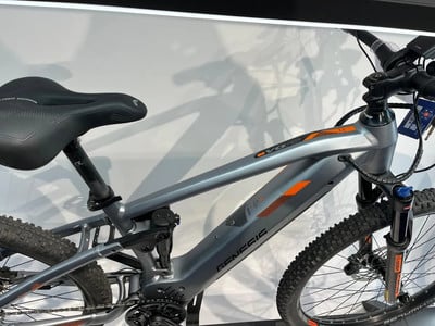 Ein Genesis Mountain-E-Bike mit Federung und orangefarbenen Details. Ein Genesis Mountain-E-Bike mit Federung und orangefarbenen Details.