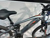 Ein Genesis Mountain-E-Bike mit Federung und orangefarbenen Details.