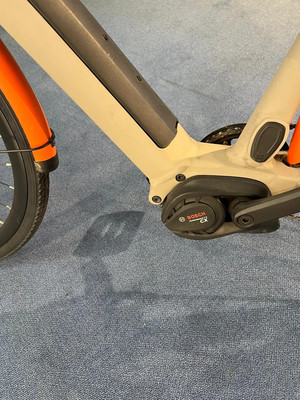 Detail eines E-Bikes mit Bosch-Motor und orangefarbenem Schutzblech.